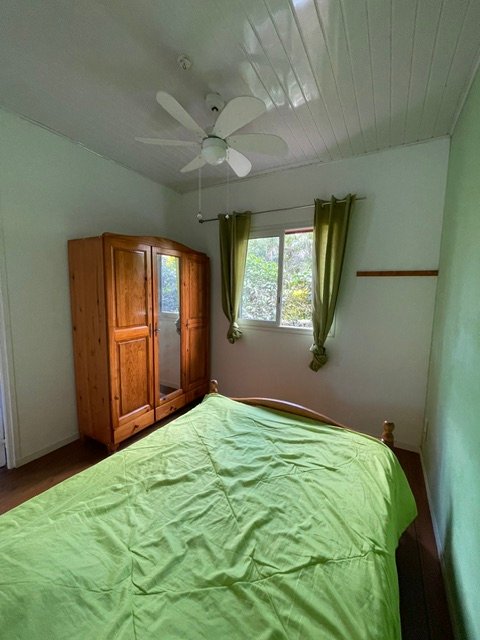 Chambre verte avec armoire et ventilateur